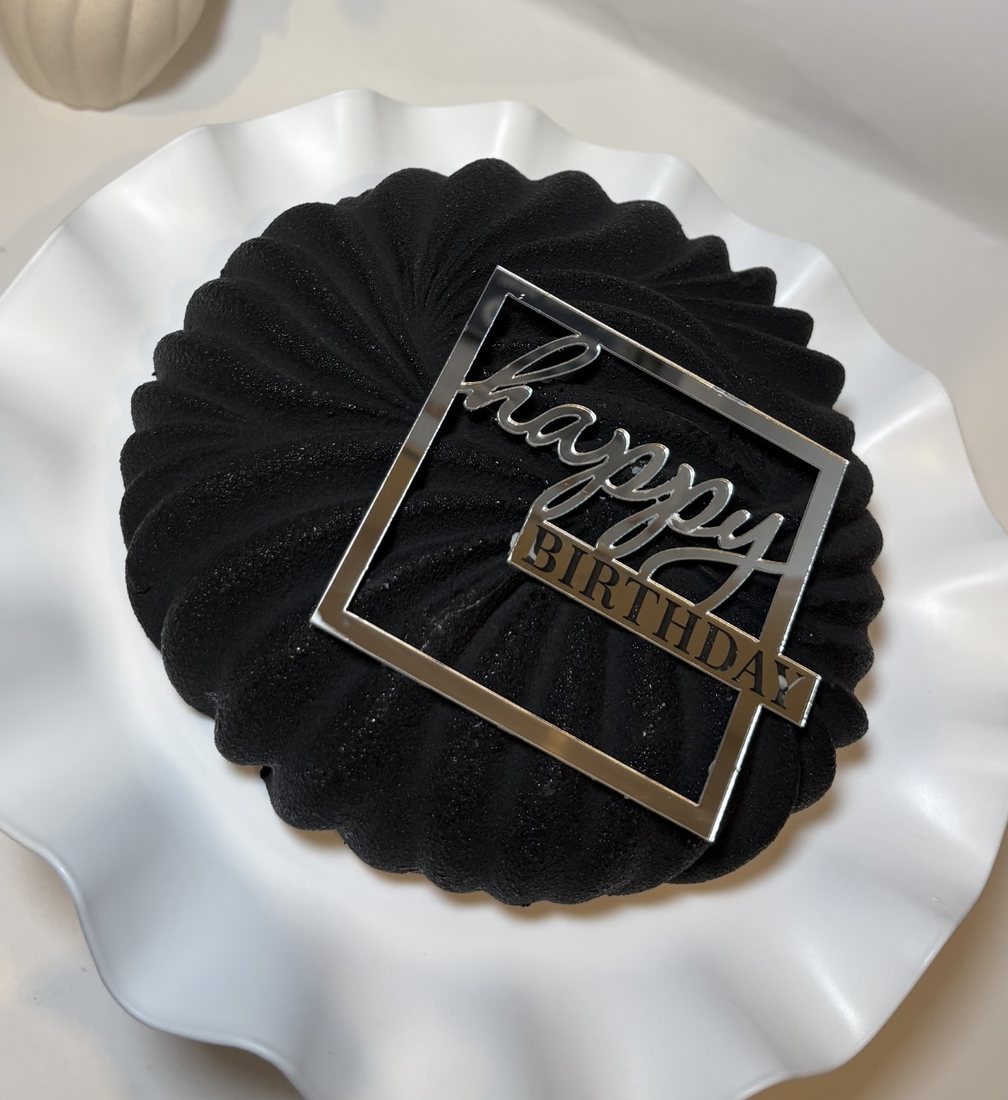 Black pleated mousse cake with a mirror Happy Birthday topper