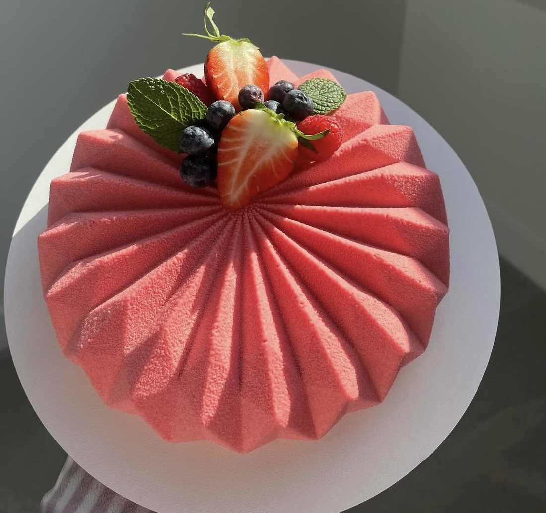 Coral pleated mousse cake with strawberries, blueberries and mint