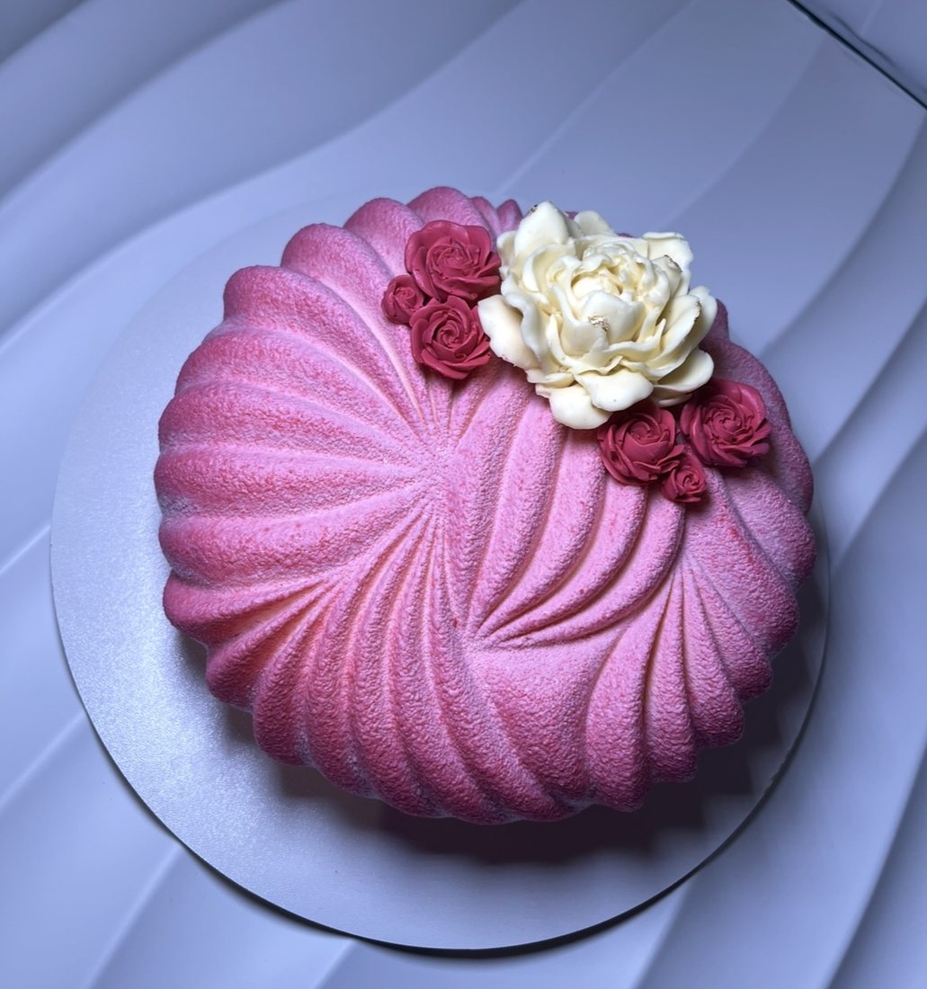 Pink pleated mousse cake with red and white sugar roses