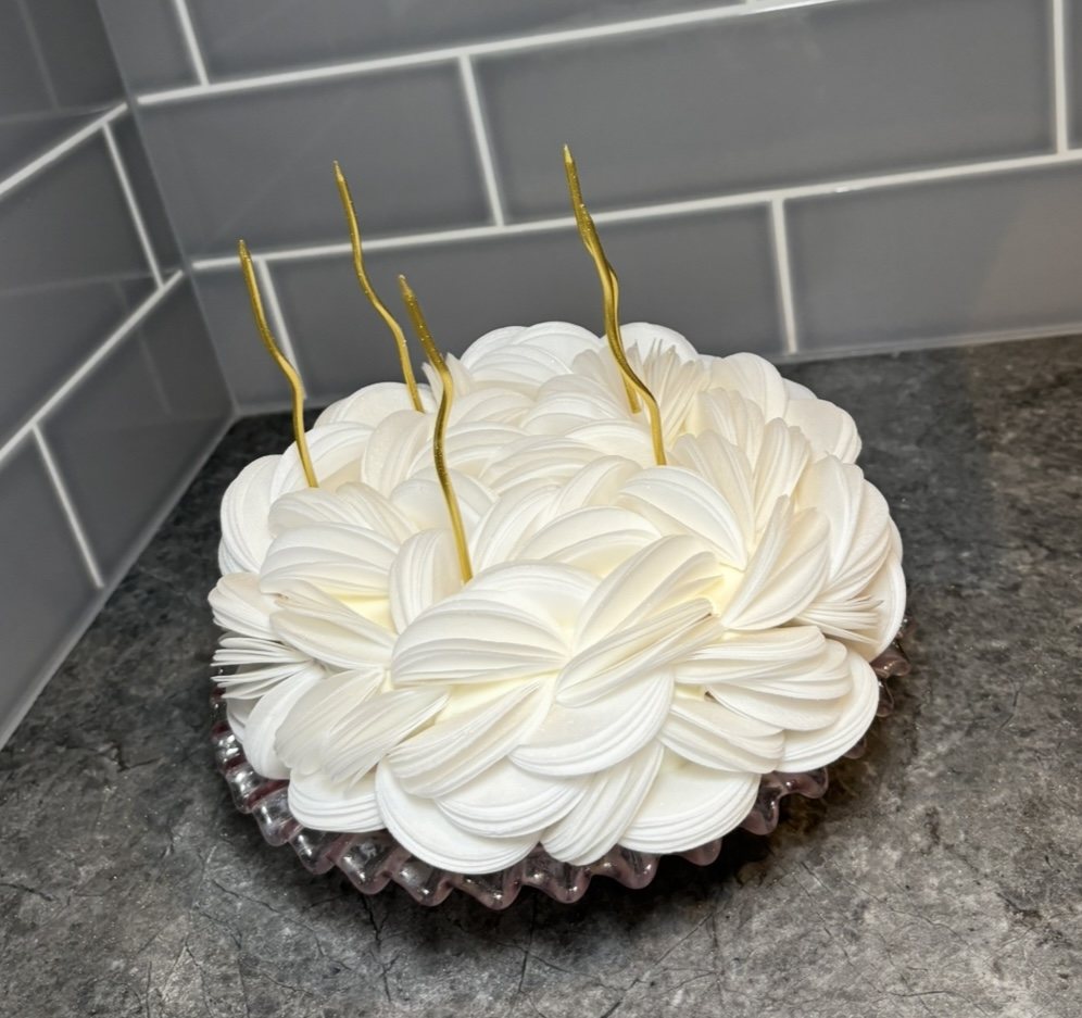 White petal textured mousse cake with gold candles