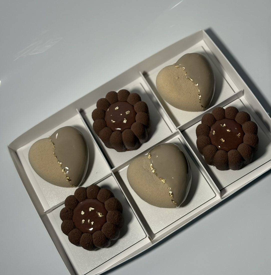 Set of six chocolate and taupe mousse cakes with gold leaf