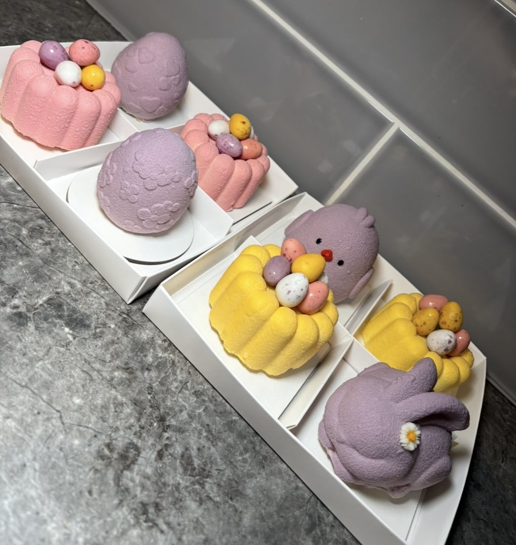Pastel pink, purple and yellow Easter themed mousse cakes with mini eggs