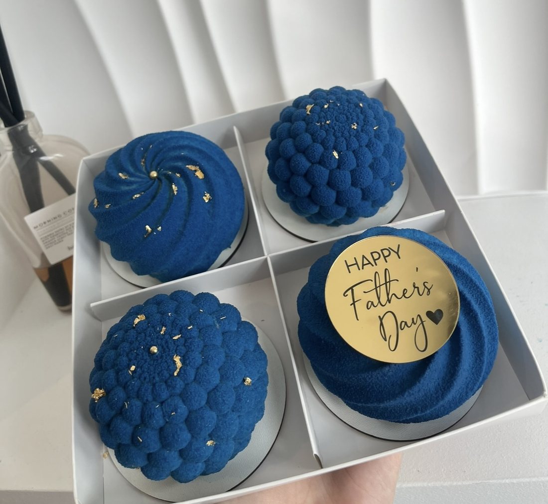 Set of four blue Father's Day mousse cakes with gold leaf
