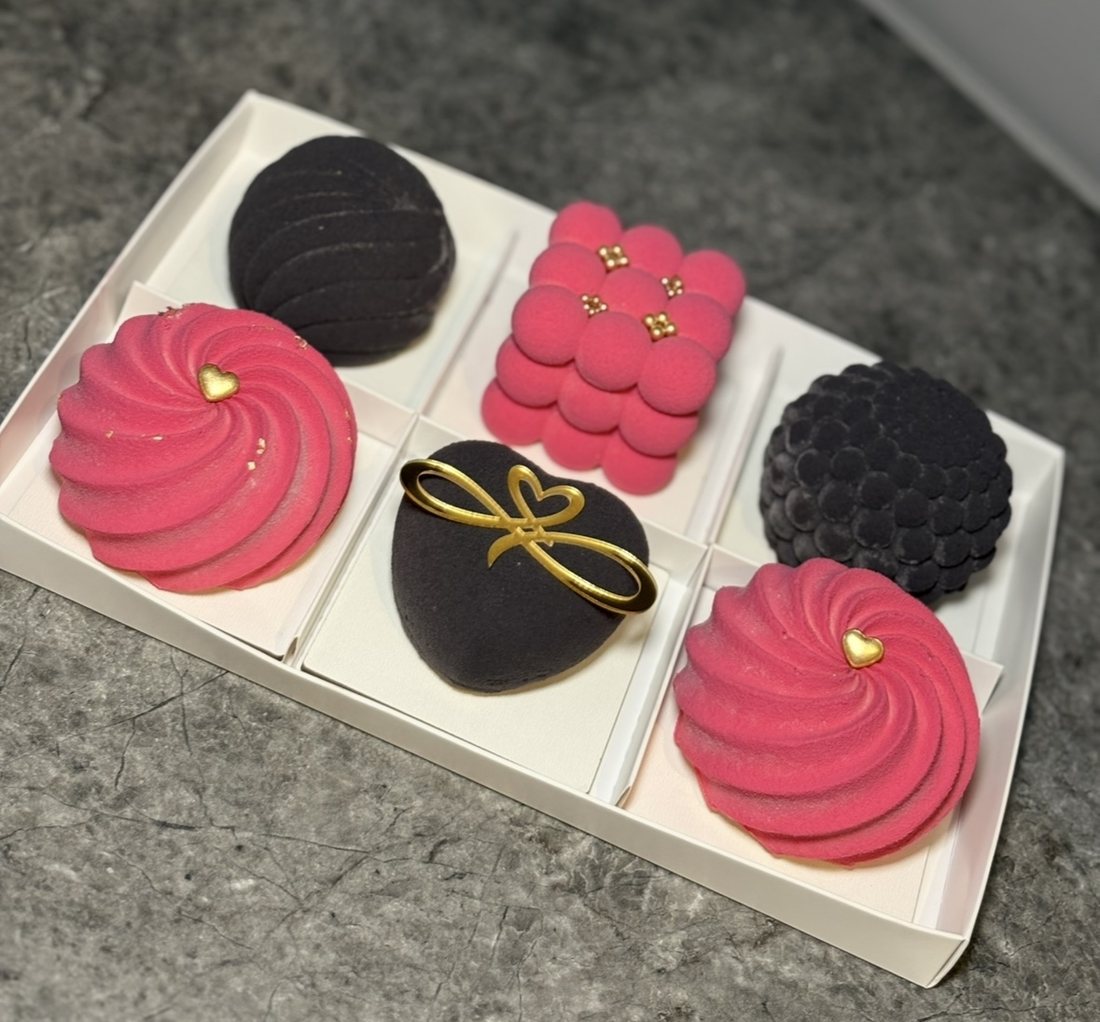 Pink and black mousse cakes with a gold bow decoration