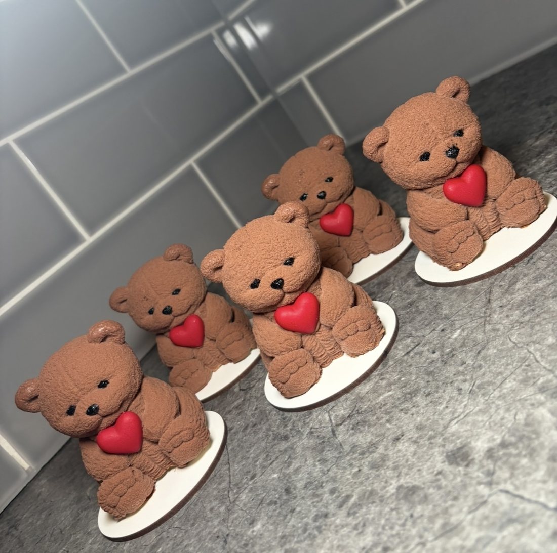 Five teddy bear mousse cakes with red heart decorations