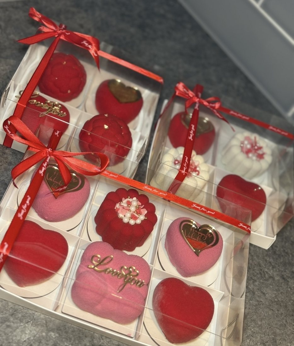 Red and pink Valentine's mousse cakes in ribboned gift boxes
