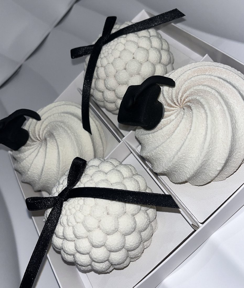 White textured mousse cakes with black bow decorations